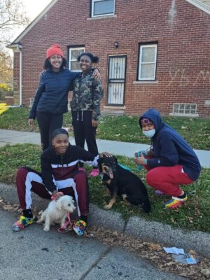 Teenagers posing with Detroit Pit Crew Dog Rescue Animals.